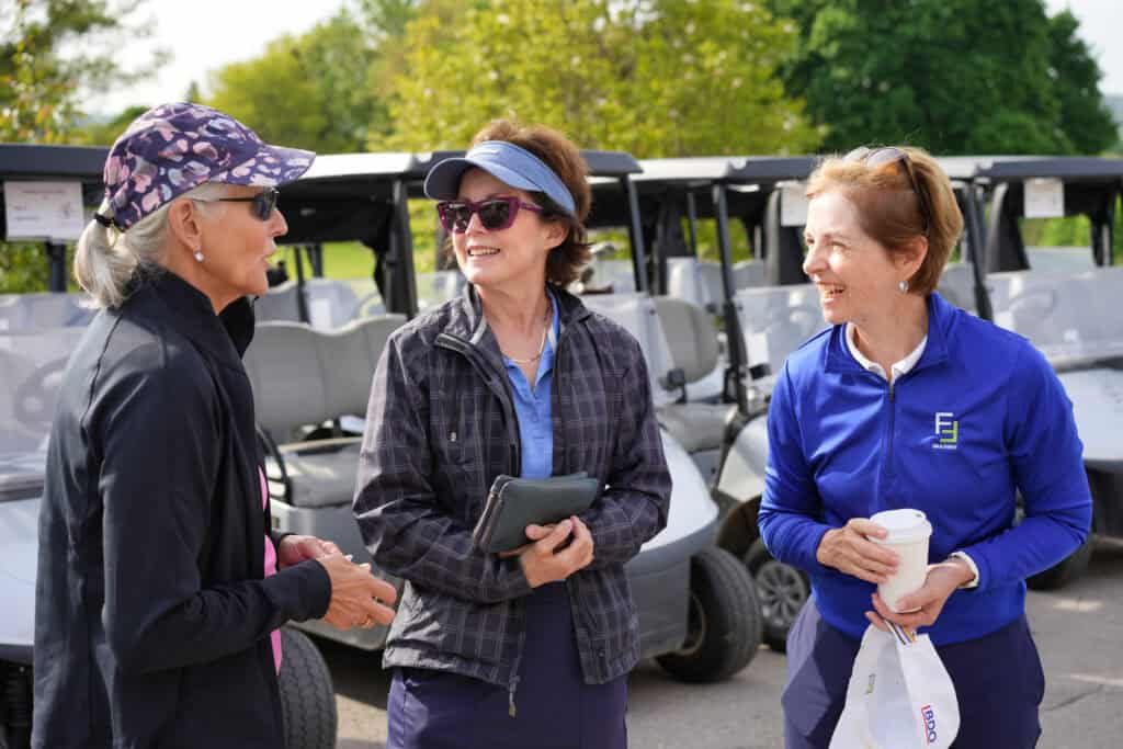 Far Samji coaching women golfers on the course